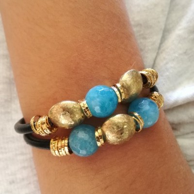 Pulseira dupla com contas azuis e douradas no pulso