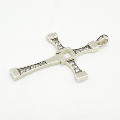 Pendente prateado em forma de cruz com pedras brilhantes num fundo branco