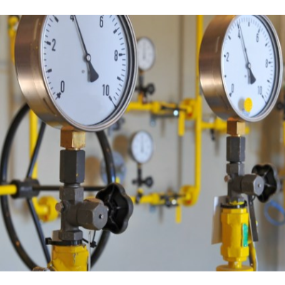 Manómetros redondos com válvulas e tubulação amarela em ambiente industrial