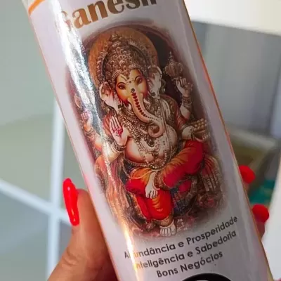 Vela branca com imagem de Ganesh e texto em português