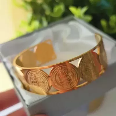 Pulseira dourada com medalhas redondas decorativas com figuras e inscrições