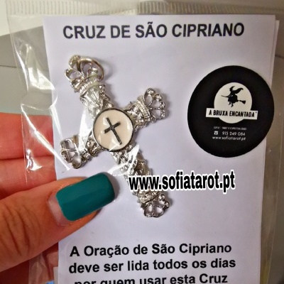 Cruz metálica prateada embalada com cartão de instruções em português