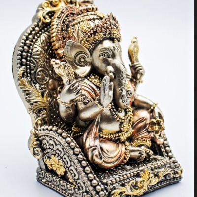 Estátua de Ganesha em metal com detalhes dourados sentada num trono decorado