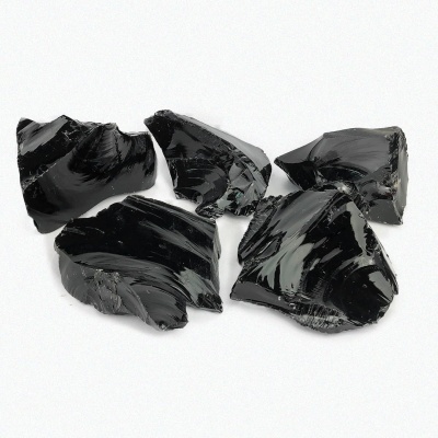 Cinco pedras pretas brilhantes com textura vítrea sobre fundo branco