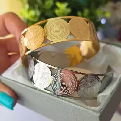 Pulseiras metálicas dourada e prateada com moedas decorativas em caixa cinza