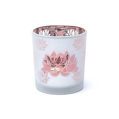 Vela em copo de vidro branco com flores de lótus cor de rosa