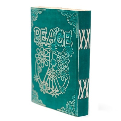 Livro decorativo verde turquesa com a palavra PEACE e símbolo de paz com flores na capa