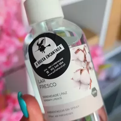 Frasco de spray transparente com rótulo branco, flores de algodão e autocolante preto da marca