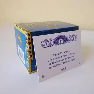 Caixa azul com detalhes dourados e papel branco com mensagem motivacional e número 13