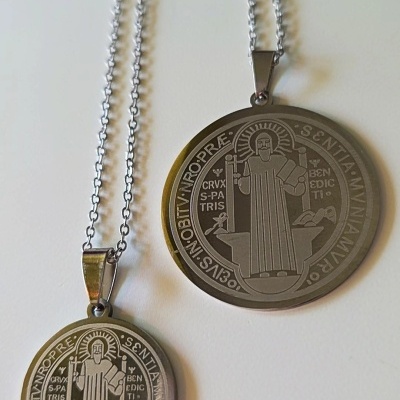 Duas medalhas redondas de metal com correntes e gravuras religiosas
