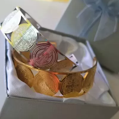 Duas pulseiras metálicas com discos gravados em caixa cinzenta com laço