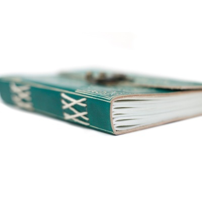 Caderno de capa dura verde com costura branca na lombada e páginas brancas