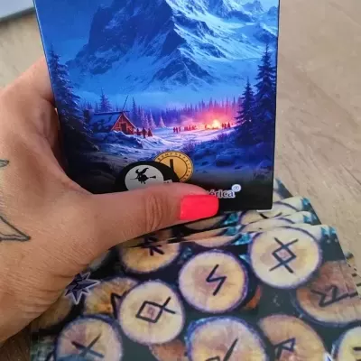 Caixa do jogo JOGO DAS RUNAS com ilustração de montanha nevada e cartas com runas sobre mesa