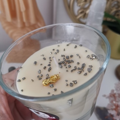 Vela branca em copo de vidro com cristais pretos e pedaço dourado