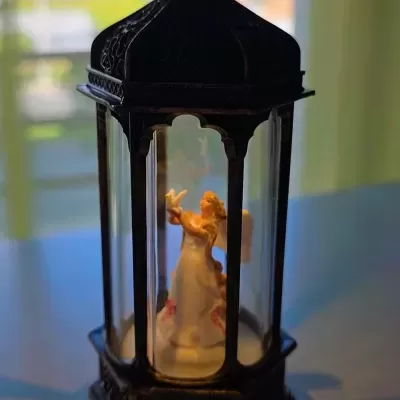 lanterna decorativa preta hexagonal com figura de anjo no interior