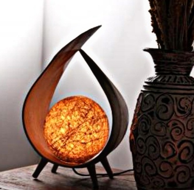 Candeeiro de mesa com estrutura curva e esfera iluminada ao lado de vaso decorativo escuro