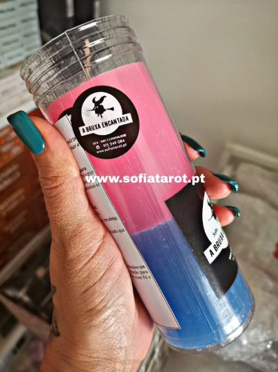 Vela bicolor rosa e azul com etiqueta A BRUXA ENCANTADA segurada pela mão