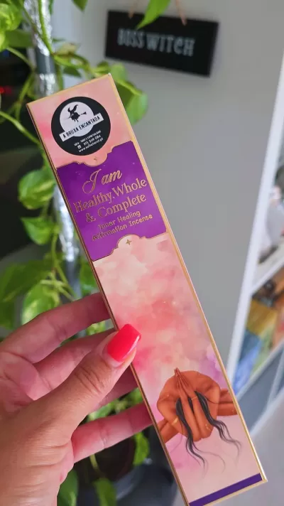 Embalagem rosa e roxa de incenso com selo e ilustração de mãos entrelaçadas