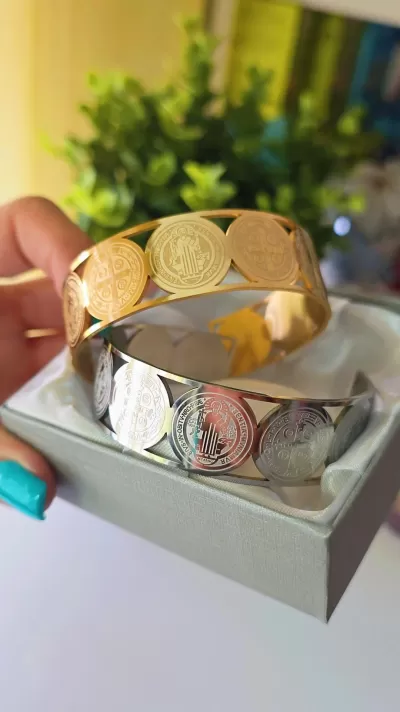 Pulseiras metálicas dourada e prateada com moedas decorativas em caixa cinza