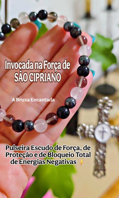 Pulseira esférica em cores preto, rosa e castanho translúcido segurada por uma mão.