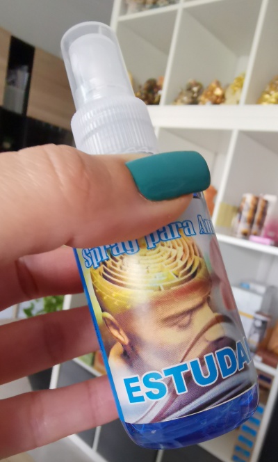 Frasco de spray azul com rótulo colorido e texto 'ESTUDA'