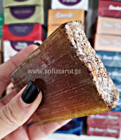 Sabonete artesanal retangular com partículas e caixas coloridas ao fundo