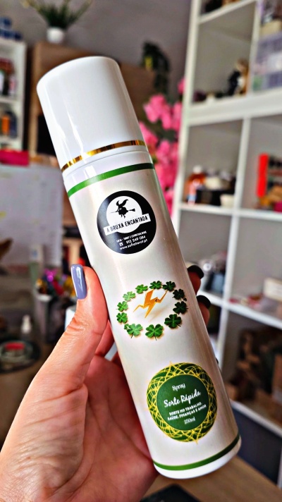 Frasco branco de spray com detalhes verdes e dourados e texto promocional em português