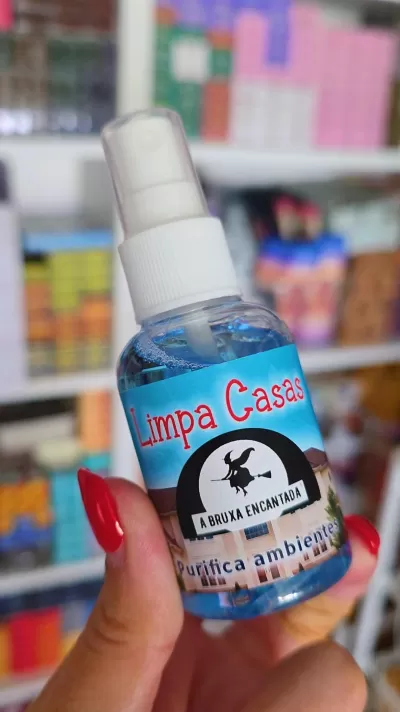 Frasco de spray azul com tampa branca e etiqueta colorida com texto Limpa Casas e A BRUXA ENCANTADA