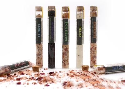 Tubos de sais de banho coloridos com tampas de cortiça e etiquetas de nomes distintos