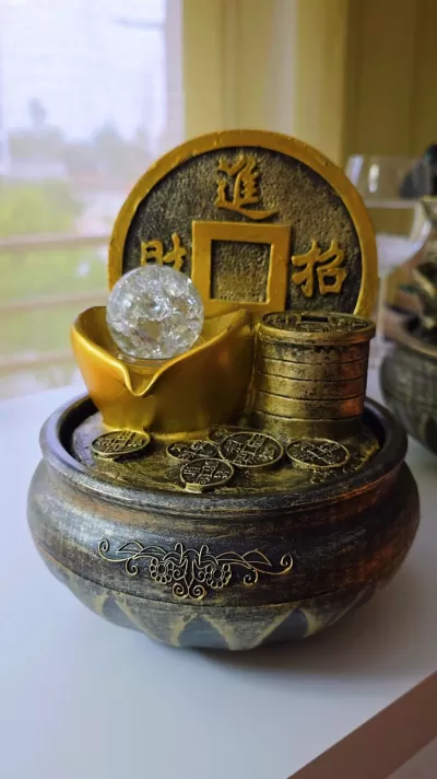 Fonte decorativa com moedas chinesas douradas e esfera transparente