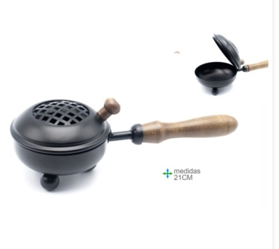 Caixa metálica preta com tampa perfurada e pega em madeira clara para queimar carvão