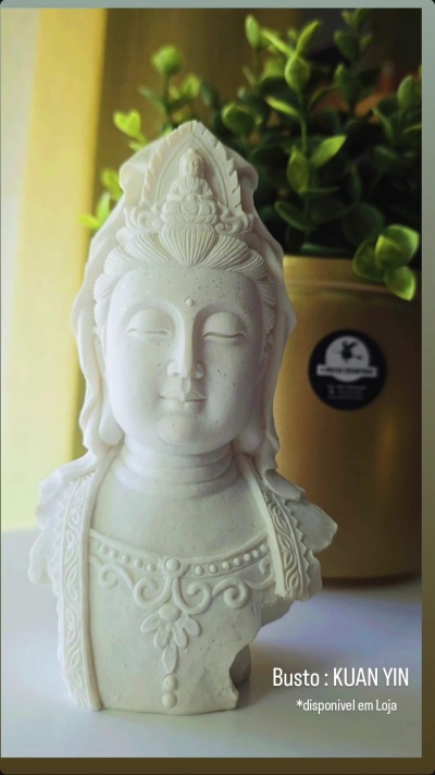 Busto branco de Kuan Yin com planta ao fundo
