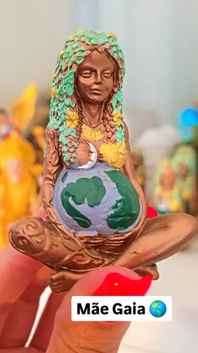 Estátua decorativa de uma figura feminina com globo terrestre na barriga.