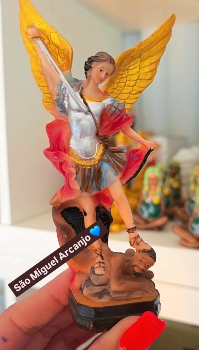 Estatueta colorida de São Miguel Arcanjo em pose de vitória com asas douradas