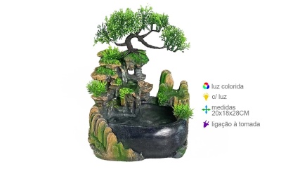 Fonte decorativa de interior com árvore, vegetação verde e base preta.