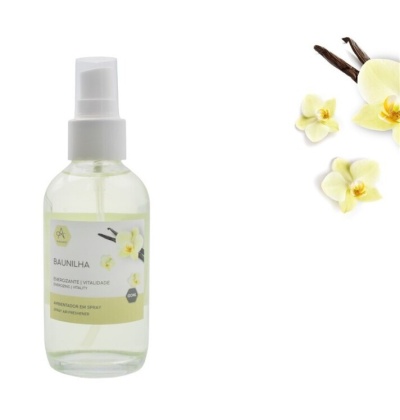 Frasco de spray de baunilha com flores e vagens numa superfície branca
