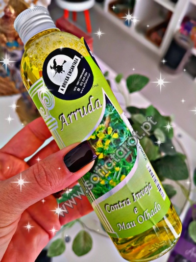 Frasco de líquido amarelo com rótulo verde e texto contra inveja e mau olhado