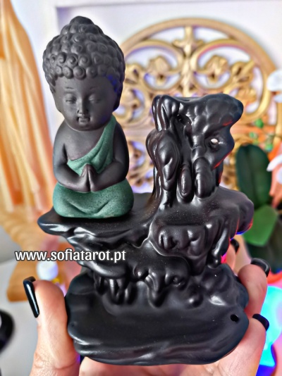 Estátua decorativa de Buda cinza escuro com túnica verde sentada em base preta com forma orgânica