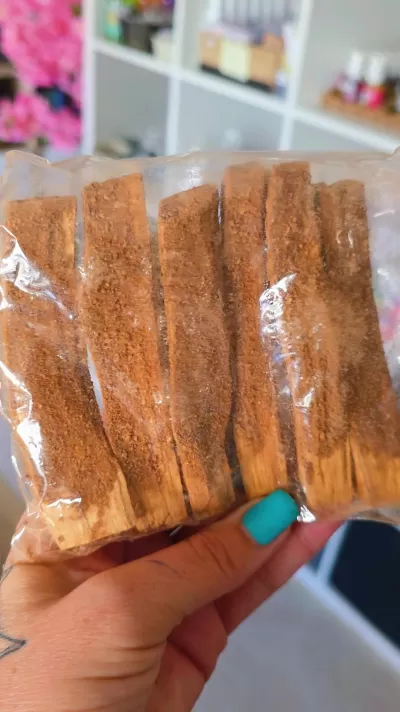 Conjunto de varas de madeira castanho escuro embaladas em saco plástico transparente.