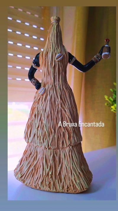 Estátua decorativa de figura feminina com saia texturizada e pele negra pintada