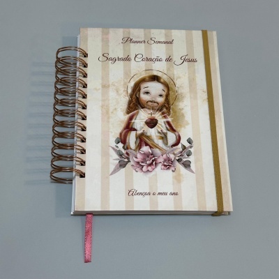 Agenda semanal com ilustração do Sagrado Coração de Jesus e texto na capa