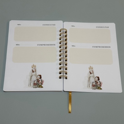 Agenda aberta com páginas para consultas e compromissos, com ilustração religiosa no canto inferior direito