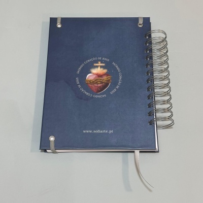 Caderno azul com espiral e ilustração Sagrado Coração de Jesus