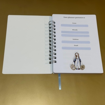 Planner aberto com campos para informação pessoal e ilustração religiosa