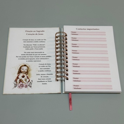 Caderno aberto com oração e formulário para contactos com argolas e marcador rosa