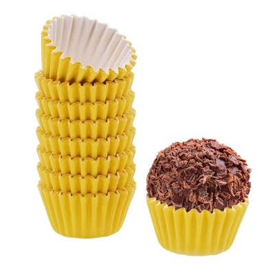 Forminhas amarelas de papel para brigadeiros com brigadeiro coberto de chocolate.