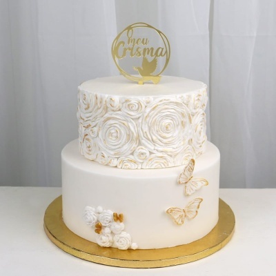Bolo de duas camadas branco com detalhes dourados e topo O meu Crisma