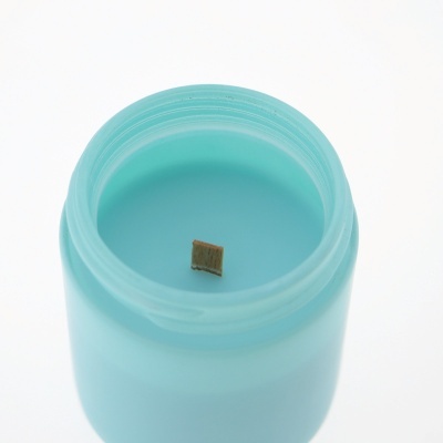 Vela aromática azul com pavio de madeira em frasco fosco