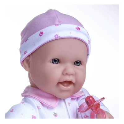 Boneca bebé com chapéu rosa e roupa branca com flores segurando chupeta rosa