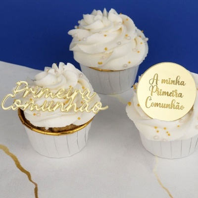 Três cupcakes decorados para Primeira Comunhão com toppers dourados e cobertura branca com pérolas.